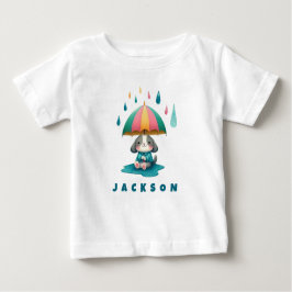 水たまりに座る傘のかわいいワンちゃん ベビーTシャツ