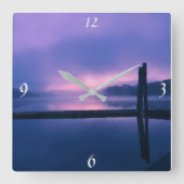 水の上に穏やかな紫/ピンクの日の出の風景 スクエア壁時計 (正面)
