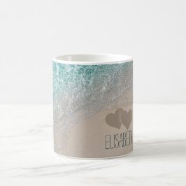 水の海の砂によって切り分けられるハートは名前を加えます コーヒーマグカップ
