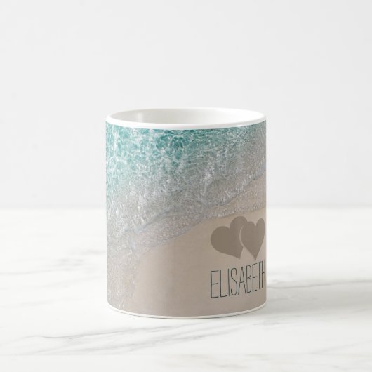 水の海の砂によって切り分けられるハートは名前を加えます コーヒーマグカップ (中央)