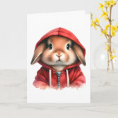 水彩画の茶色のウサギが赤いフードを着ている カード (黄色い花)