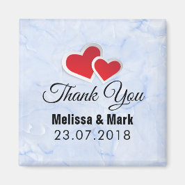 氷のような青い大理石の背景に2つの赤い紙のハートのウェディング マグネット