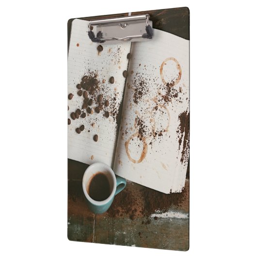 汚れた本と豆が入った熱いコーヒー クリップボード (左)