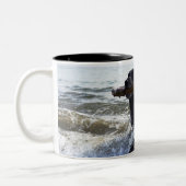 波を通る黒いラブラドル・レトリーバー犬のランニング、 ツートーンマグカップ (左)
