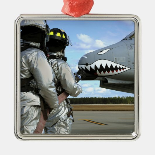 消防士はドリル中に消防用ホースを配備する メタルオーナメント (正面)