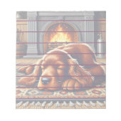 温かい暖炉のそばで眠るアイリッシュセッターの子犬 ノートパッド (正面)