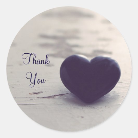 濡れた砂の上に濃い紫色の石のハートビーチ ラウンドシール (正面)