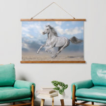 灰色のアラビア馬が砂地を駆け抜ける