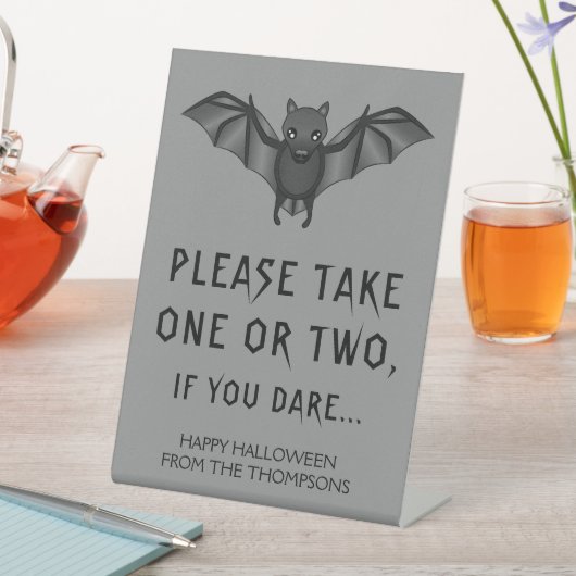 灰色の漫画こうもりハロウィーンお菓子を取って 台座サイン (インサイチュ)