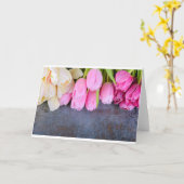 灰色の石の背景に新鮮なピンクのチューリップ カード (黄色い花)