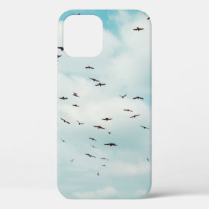 灰色の鳩の群れがヴィンテージ青空を飛ぶ。上 iPhone 12ケース