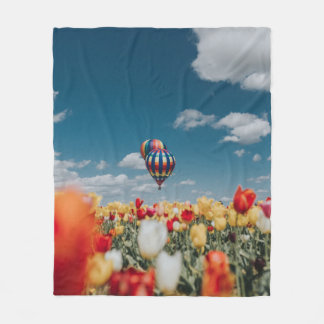 熱気球の下に黄色と赤のチューリップの花が咲く フリースブランケット