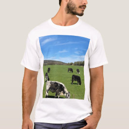 牛が緑の野で放牧 Tシャツ