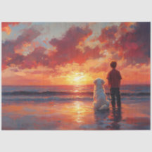 犬と少年がビーチで夕日を見ている