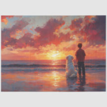 犬と少年が夕日を眺めるビーチ