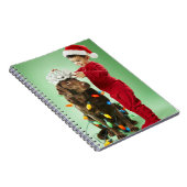 犬のまわりでクリスマスの照明を包んでいる若い男の子 ノートブック (右側)