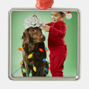 犬のまわりでクリスマスの照明を包んでいる若い男の子 メタルオーナメント