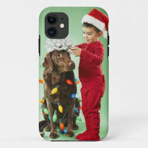 犬のまわりでクリスマスの照明を包んでいる若い男の子 iPhone 11 ケース