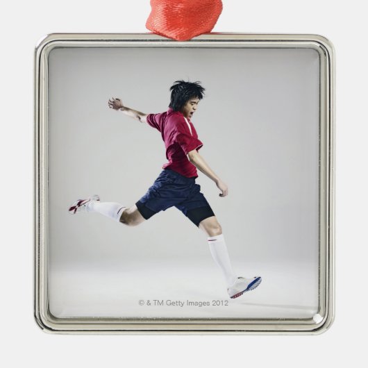 球を蹴ることを準備しているオスのサッカーの選手 メタルオーナメント (正面)