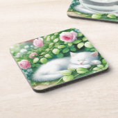 甘い白い子猫がバラの茂みの下で昼寝 コースター (左側)