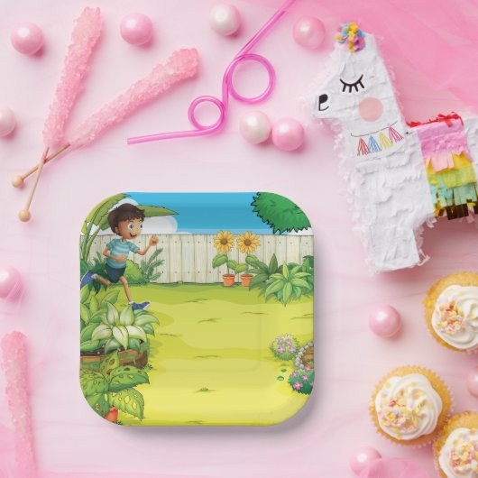 男のよくはしゃぐ子の走が緑豊かな裏庭に ペーパープレート (パーティー)