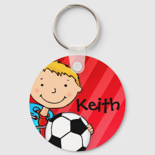 男の子はフットボールの赤のスポーツのkeychainを示しました キーホルダー