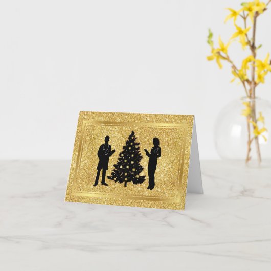 男性と女性の医者のシルエットがクリスマスツリーとともに明るい金色の背景にデザインされたクリスマスカー カード (黄色い花)