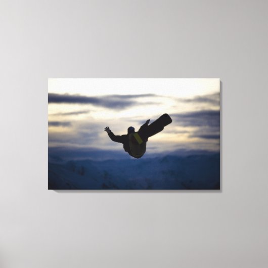 男性のスノーボーダーは乗馬の間にバックフリップをする キャンバスプリント (正面)