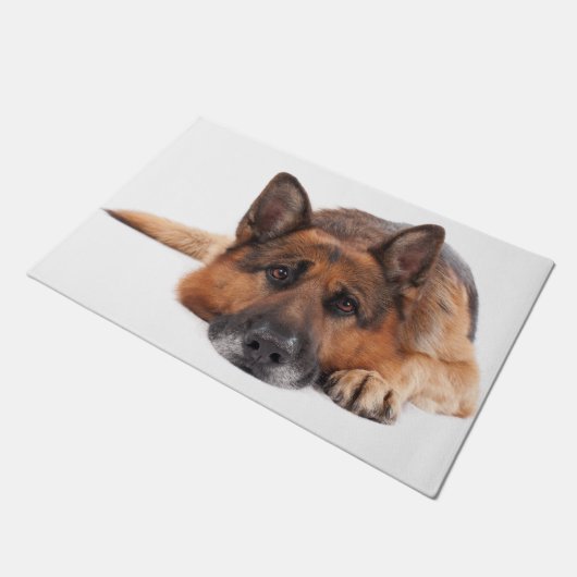 白い背景に横たわるドイツの羊飼い ドアマット (アングル)