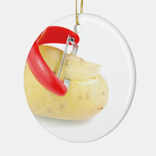 白い背景のポテトをスライスしている赤いピーラー セラミックオーナメント (左)
