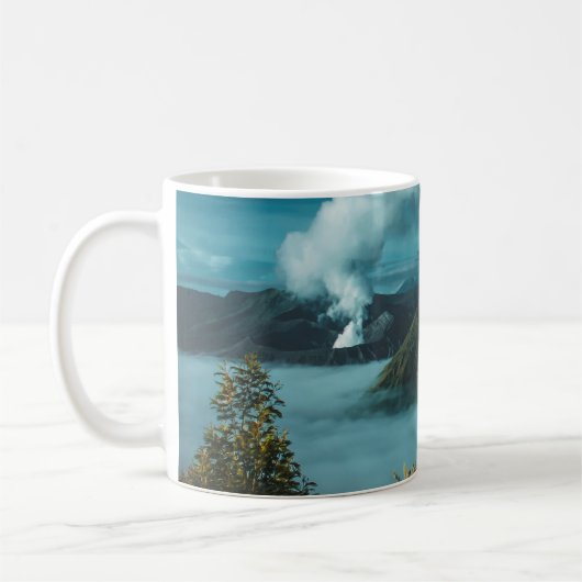 白い雲に囲まれた緑の山々 コーヒーマグカップ (左)