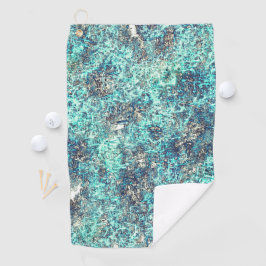 白っぽい灰色のラフの上に金色のオレンジ色で覆われた ゴルフタオル