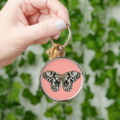 白と黒の蝶、コーラルピンク背景 キーホルダー (手)