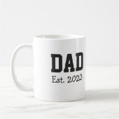 白地に太字のブラックテキストで「Dad Established」 コーヒーマグカップ (左)