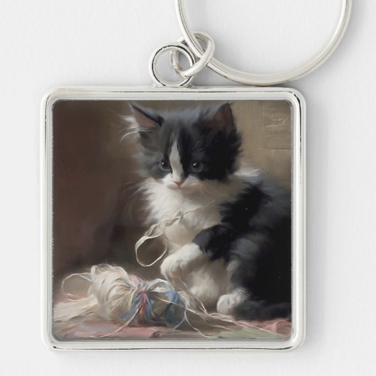 白黒の子猫におもしろいが絡まっている キーホルダー (正面)