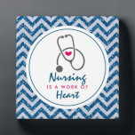 看護は聴診器を用いたハートことわざの仕事 フォトプラーク<br><div class="desc">青い山形のグリッター模様のフェイク写真プラーク。実際のグリッターではなく、単なる画像。上に積層されて白いフレームと内側はことわざ：看護はハートの仕事で、小さな赤いハートと灰色の聴診器を持っている。</div>