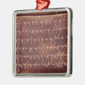 石棺からの銘刻文字の メタルオーナメント (左)