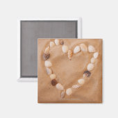 砂の上に貝殻で作られたハートの形状のクローズアップ マグネット (正面/裏面)