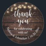 私たちのステッ祝カーをありがとうござ結婚う ラウンドシール<br><div class="desc">私たち祝のステッカー、素朴なスクリプ結婚ト書で、コテージパーティーストリングライト、ダークブラウンの木の背景をありがとう。</div>