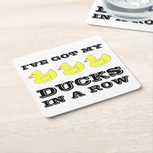 私はアヒル得に黄色いゴムのダッキー(アヒルちゃん)を並べている スクエアペーパーコースター (アングル)