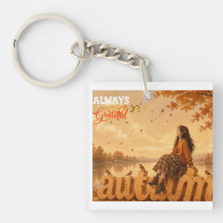 秋の女の子が"Autumn"の文字の上に座っている キーホルダー