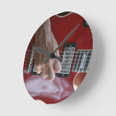 積み込みの近くで赤いエレキギターを演奏する手 ラウンド壁時計 (傾斜)
