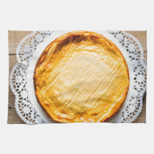 粗末なウッドケーキの上にチーズケーキを乗せる。 キッチンタオル
