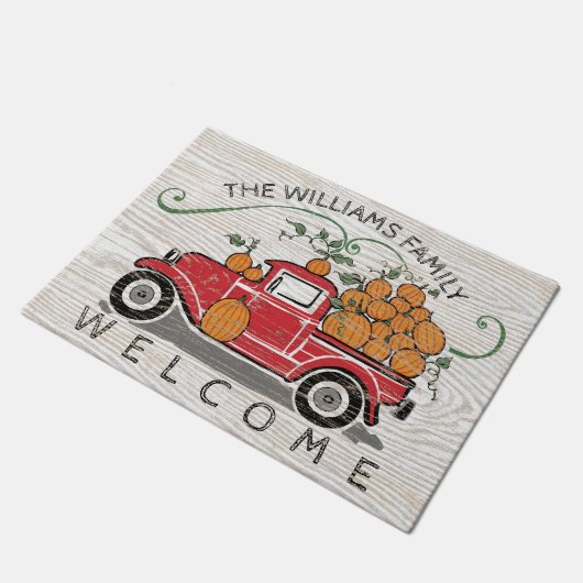 素朴なヴィンテージの赤いトラックのカボチャモノグラムの歓迎 ドアマット (アングル)