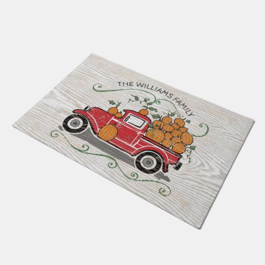 素朴なヴィンテージの赤いトラックのカボチャ姓 ドアマット (アングル)