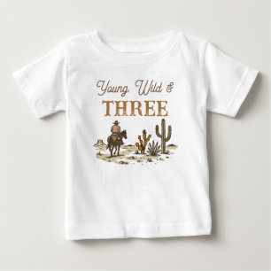 素朴な茶色のカウボーイ　ヤング ワイルド アンド スリー バースデー ベビーTシャツ