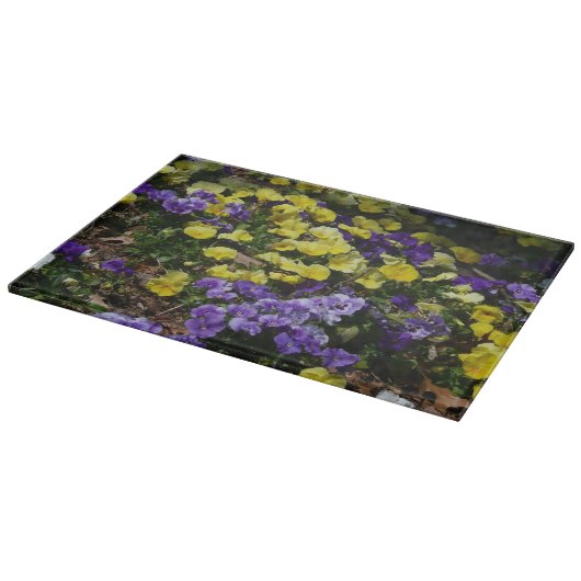 紫と黄色のパンジーの丘の斜面 カッティングボード (角)