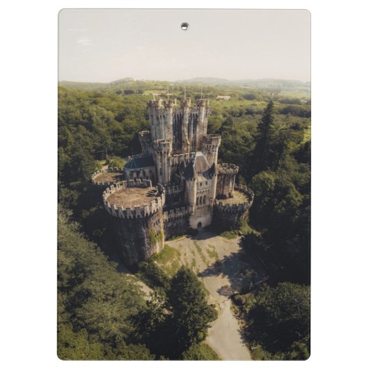 緑に覆われた森の背の高い灰色の石の城 クリップボード (裏面)
