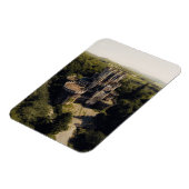 緑に覆われた森の背の高い灰色の石の城 マグネット (左側)