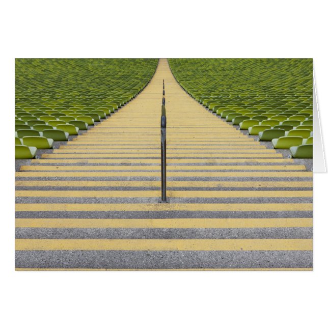 緑の座席の列間の競技場の階段 (正面横)